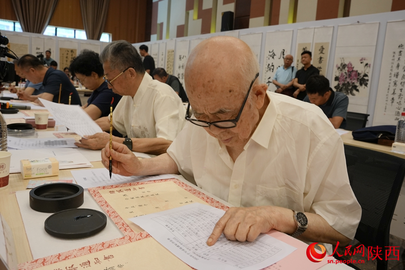 退休教師用毛筆為今年新生手寫錄取通知書。人民網(wǎng)記者 賈凱璐攝